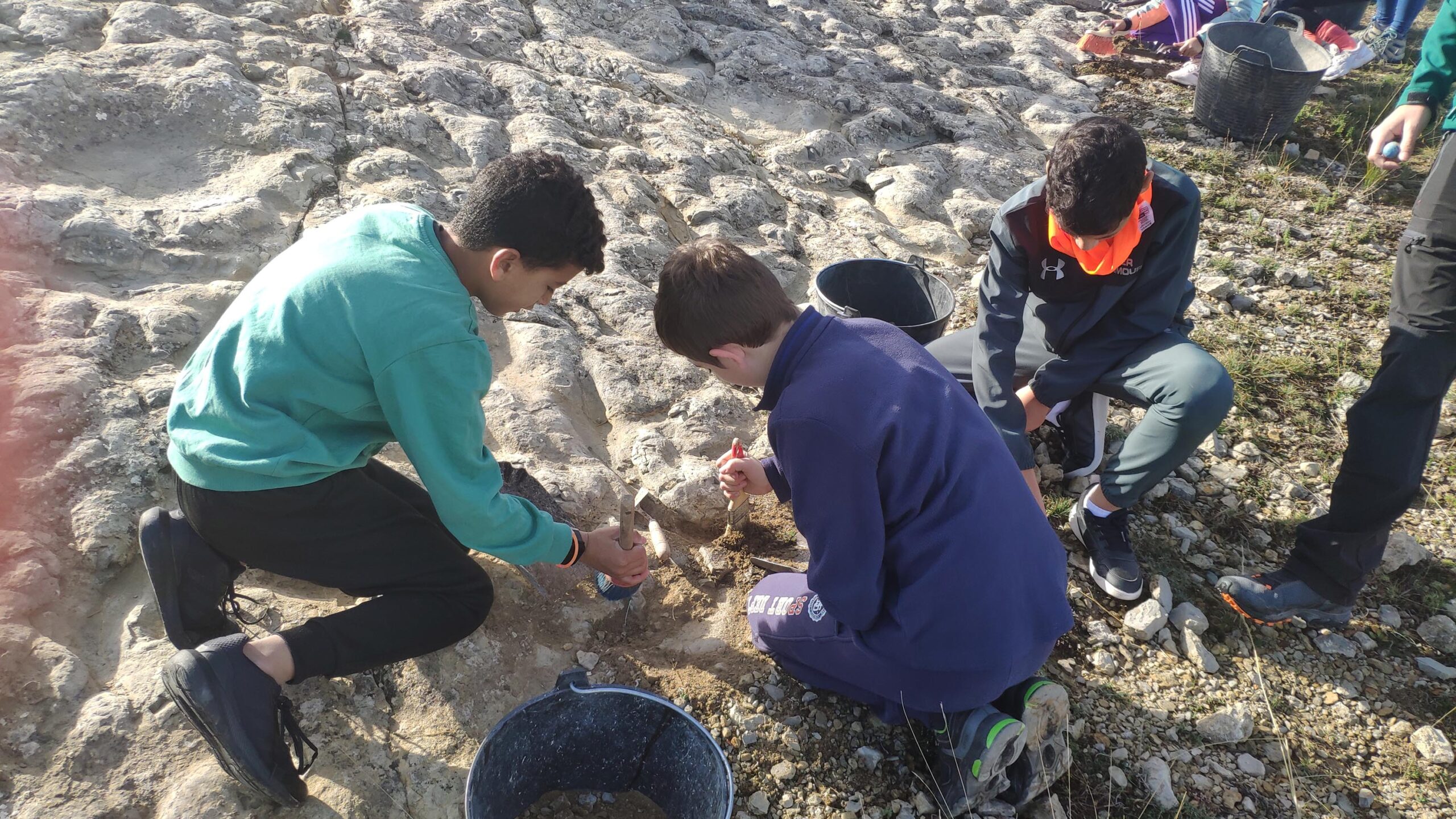 alumnos CRA Cedrillas excavando y limpiando el yacimiento actividad Fundación Dinópolis